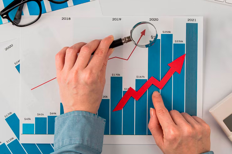 top-view-office-desk-with-growth-chart-hands-holding-magnifying-glass_23-2148780614